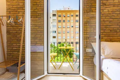 a room with a balcony with a table and a bed at Private room Beach Valencia in Valencia