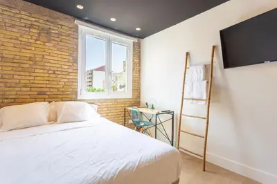 a bedroom with a white bed and a brick wall at Private room Beach Valencia in Valencia
