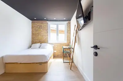 a small bedroom with a bed and a window at Private room Beach Valencia in Valencia