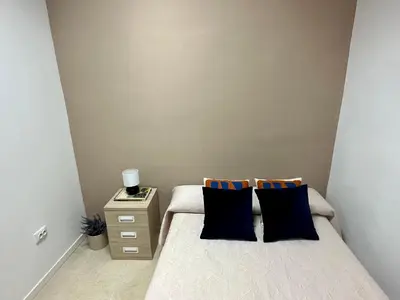 a bedroom with a bed with two pillows and a night stand at The Valencia Stop in Valencia