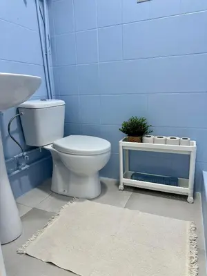a blue bathroom with a toilet and a sink at The Valencia Stop in Valencia