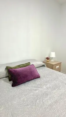 a bed with a purple pillow on top of it at The Valencia Stop in Valencia