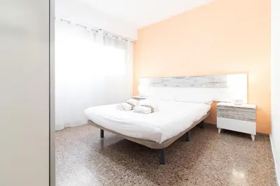 a bedroom with a bed and a mirror at Global Vacacional, Practico apartamento para 6 personas en Puerto Sagunto in Puerto de Sagunto