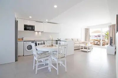 a kitchen and living room with a table and chairs at Global Vacacional, Apartamento con 2 terrazas en Gran Canet in Canet de Berenguer