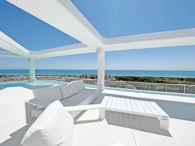 a patio with a couch and a view of the ocean at Global Vacacional, Apartamento con 2 terrazas en Gran Canet in Canet de Berenguer