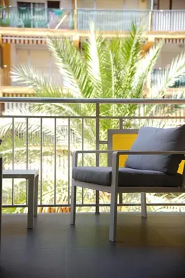 a bench and a table on a balcony with a palm tree at Luxury apartment Y after renovation in Cullera with parking in Cullera