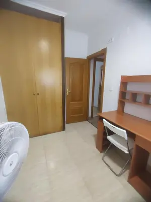 a room with a desk and a table and a fan at Planta baja, bien comunicada, cerca de la playa. in Valencia