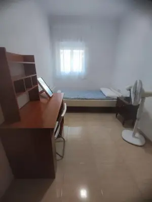 a small room with a bed and a desk and a desk at Planta baja, bien comunicada, cerca de la playa. in Valencia