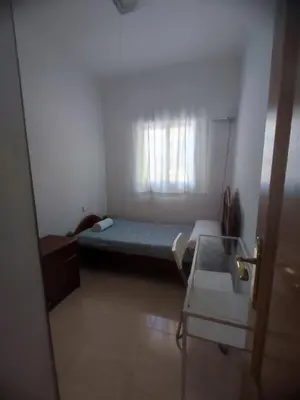 a small room with a bed and a window at Planta baja, bien comunicada, cerca de la playa. in Valencia