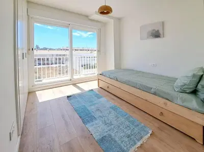 a bedroom with a bed and a large window at Charming flat close to the beach in Canet de Berenguer