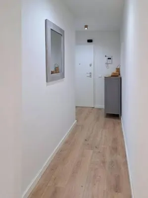 a room with a hallway with white walls and wood floors at Charming flat close to the beach in Canet de Berenguer