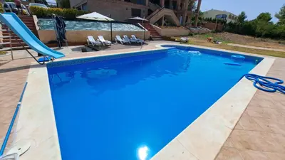 a blue swimming pool with a slide in a yard at Posada la Toscana in Montroy