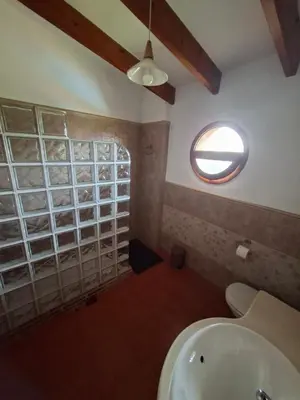 a bathroom with a sink and a round window at CortijoRamon in El Brosquil