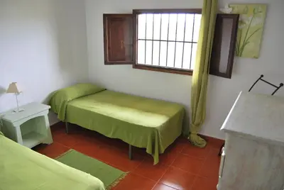 a small room with two beds and a window at CortijoRamon in El Brosquil