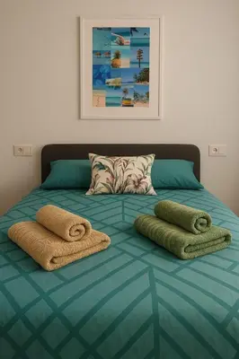 a bed with two towels on top of it at Del Mar one bed flat in Puerto de Sagunto