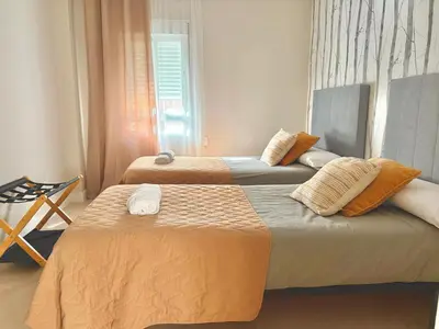 two beds in a bedroom with a window at cultura y playa in Puerto de Sagunto