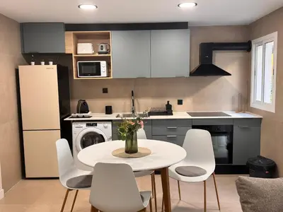 a kitchen with a white table and white chairs at cultura y playa in Puerto de Sagunto
