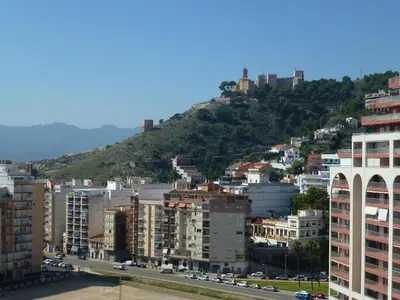 a view of a city with buildings and a mountain at Espectacular terraza y vistas en 1a línea de playa in Cullera