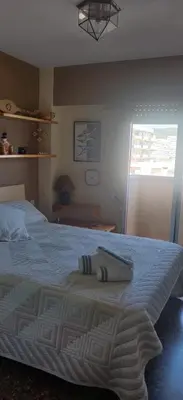 a bedroom with a large bed with a blue blanket at Espectacular terraza y vistas en 1a línea de playa in Cullera