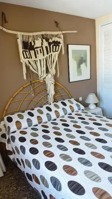 a bedroom with a bed with a black and white comforter at Espectacular terraza y vistas en 1a línea de playa in Cullera