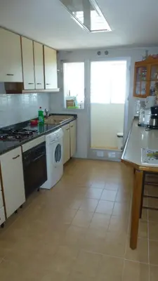 a kitchen with a stove and a washing machine at Espectacular terraza y vistas en 1a línea de playa in Cullera