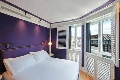a bedroom with a white bed and a purple wall at ESTIMAR Valencia in Valencia