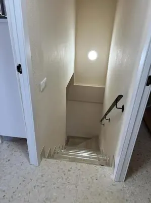 a hallway with a staircase with a black hand rail at Modern apartment in Valencia, Port Saplaya, by the sea in Port Saplaya