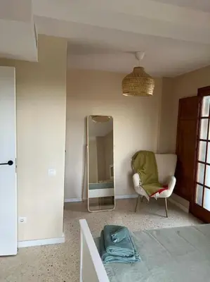 a living room with a chair and a mirror at Modern apartment in Valencia, Port Saplaya, by the sea in Port Saplaya