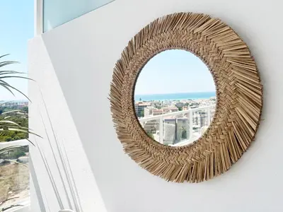 a wicker mirror on the side of a building at Global Vacacional, Bonito apartamento con terraza en Gran Canet in Canet de Berenguer