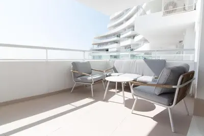 a room with two chairs and a table and a building at Global Vacacional, Nuevo apartamento con terraza en Gran Canet Residencial in Canet de Berenguer