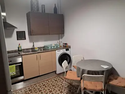 a kitchen with a table and a washing machine at Apartamento muy céntrico en Valencia junto a Ruzafa in Valencia