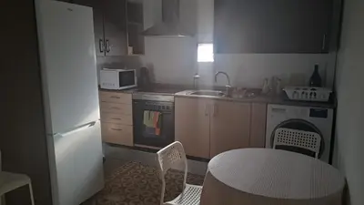 a small kitchen with a table and a white refrigerator at Apartamento muy céntrico en Valencia junto a Ruzafa in Valencia