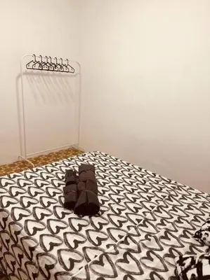 a bed with a black and white comforter on it at Apartamento muy céntrico en Valencia junto a Ruzafa in Valencia