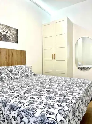 a bedroom with a black and white bed and a mirror at Acogedor apartamento 5 personas in Valencia