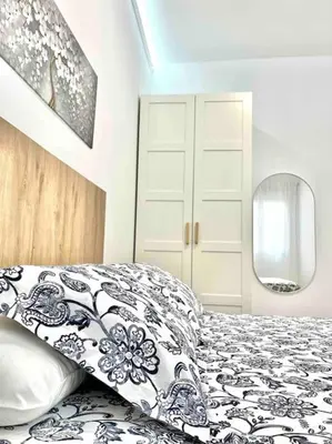 a bedroom with a black and white bed and a mirror at Acogedor apartamento 5 personas in Valencia