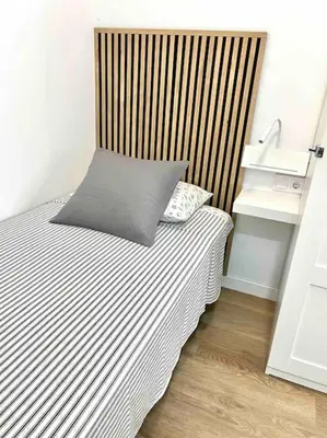 a bed with a pillow on top of it in a room at Acogedor apartamento 5 personas in Valencia