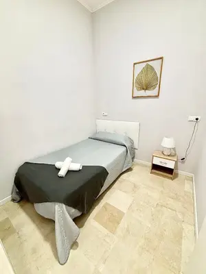 a bedroom with a bed and a table with a lamp at Apartamentos Bobal Requena in Requena