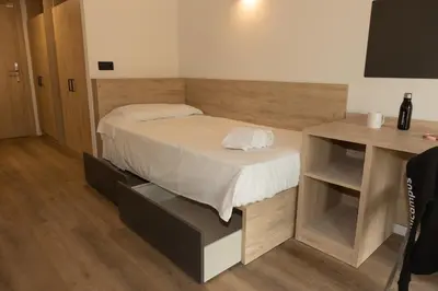 a bed in a room with a desk and a bed sidx sidx sidx at Micampus Burjassot Parque Student Residence in Burjasot