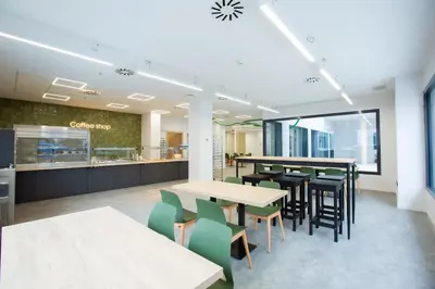 a dining area with tables and chairs in a cafeteria at Micampus Burjassot Parque Student Residence in Burjasot