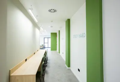 a hallway with green walls and tables and chairs at Micampus Burjassot Parque Student Residence in Burjasot