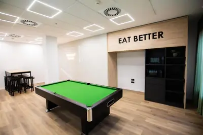 a pool table in a room with eat better sign at Micampus Burjassot Parque Student Residence in Burjasot