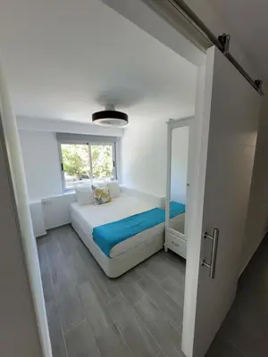 a small bedroom with a bed and a mirror at New and Bright 2-bedroom apartment in Cañamelar in Valencia