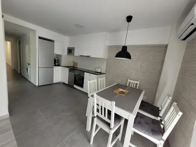 a kitchen and dining room with a table and chairs at New and Bright 2-bedroom apartment in Cañamelar in Valencia
