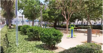 a park with a playground with trees and a bench at New and Bright 2-bedroom apartment in Cañamelar in Valencia