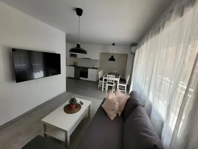 a living room with a couch and a table at New and Bright 2-bedroom apartment in Cañamelar in Valencia