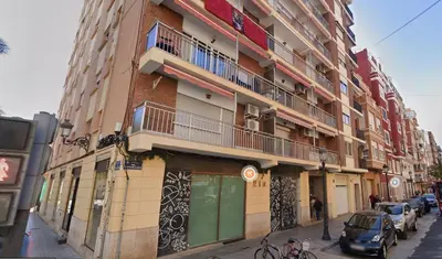 a building on a street with cars parked in front of it at New and Bright 2-bedroom apartment in Cañamelar in Valencia