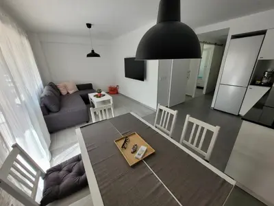 a living room with a table and a couch at New and Bright 2-bedroom apartment in Cañamelar in Valencia