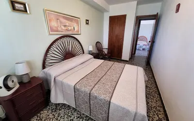 a bedroom with a bed and a dresser and a mirror at Tavernes de Valldigna Chez Svetlana in El Brosquil