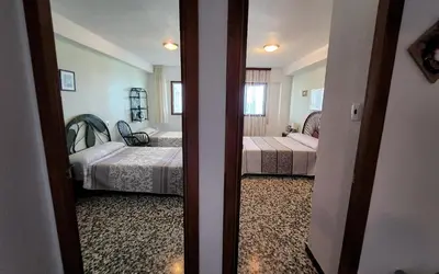 a room with two beds and a door to a bedroom at Tavernes de Valldigna Chez Svetlana in El Brosquil