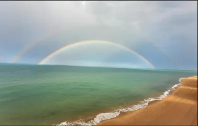 a rainbow over the beach and the ocean with a beach at Tavernes de Valldigna Chez Svetlana in El Brosquil